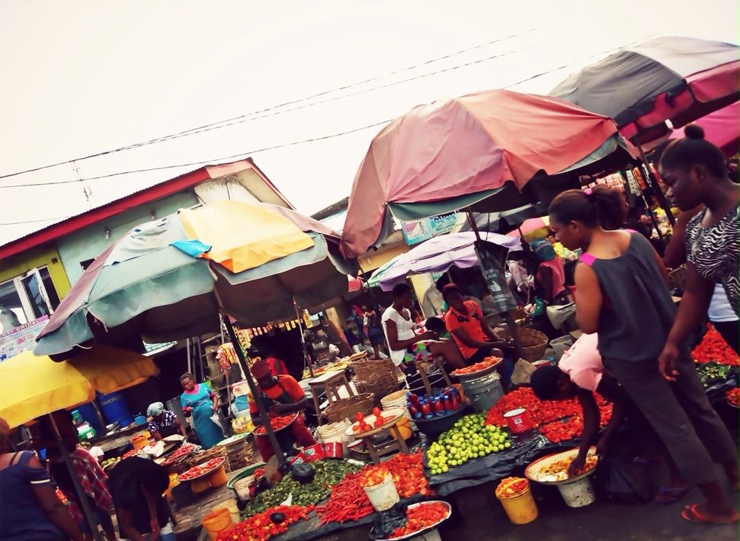Pepper, tomato and vegetable sellers under umbrellas at a market